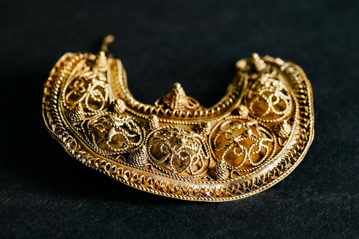 Fragment złotego kolczyka z filigranową dekoracją ze skarbu z z Hoogwoud w Holandii (ok. 1000-1050). Źródło: <a href='https://archeologiewestfriesland.nl/de-schatvondst-van-hoogwoud/' rel='noopener'>Archeologie West-Friesland</a>.