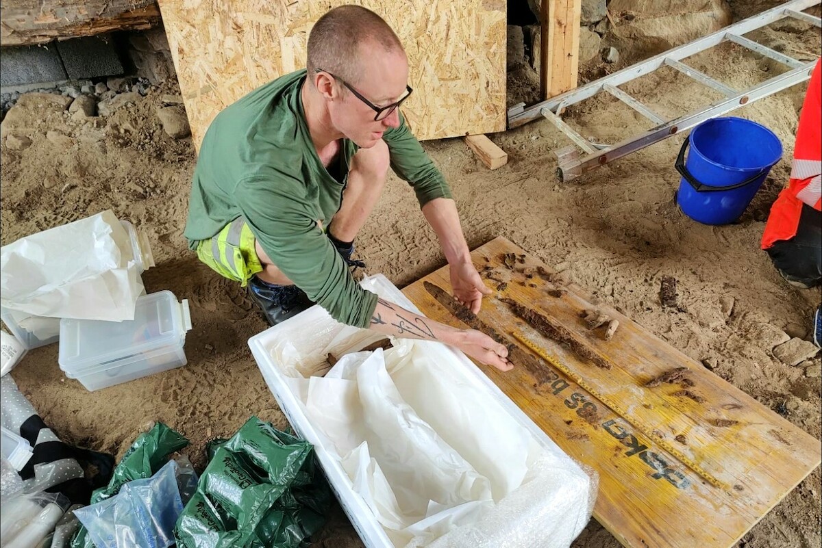 Archeolog Jo-Simon Frøshaug Stokke pakuje wczesnośredniowieczny miecz odkryty w Setesdal w Norwegii. Fot. J. Wintervoll. Źródło: <a href='https://image.sciencenorway.no/2221003.webp?imageId=2221003&x=0.00&y=1.14&cropw=100.00&croph=88.76&width=1398&height=938&format=webp' rel='noopener'>sciencenorway.no</a>.