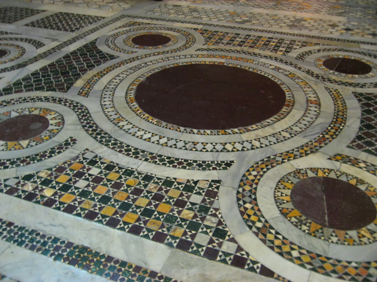 Przykład stylu Cosmatesque na posadzce Bazyliki Świętego Krzyża z Jerozolimy w Rzymie. Zdjęcie autorstwa <a href='//commons.wikimedia.org/wiki/User:Jastrow' title='User:Jastrow'>Jastrow</a> - <a href='int-own-work'>Self-photographed</a>, <a href='https://commons.wikimedia.org/w/index.php?curid=1329362'>domena publiczna</a>.