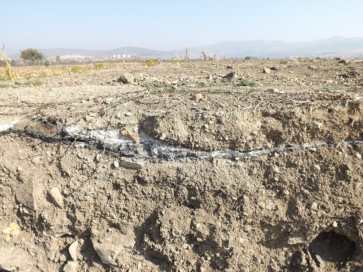 Warstwa spalenizny (popiół i węgiel drzewny) łączony z najazdem Słowian na Ulpianę w VII w. Źródło: <a href='https://upload.wikimedia.org/wikipedia/commons/thumb/6/60/Ulpiana23.JPG/1280px-Ulpiana23.JPG'>domena publiczna</a>.